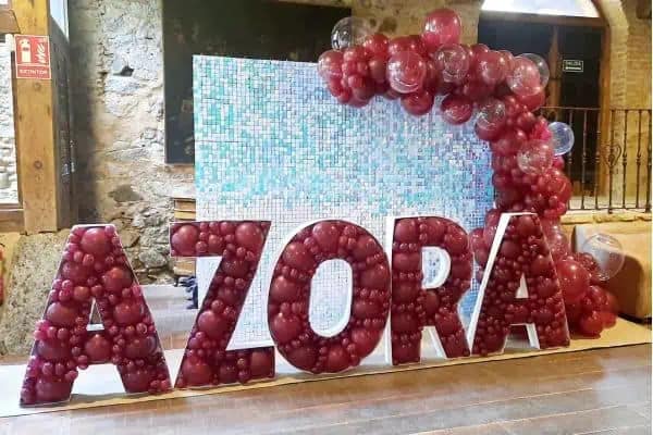 decoración de eventos corporativos con panel de lentejuelas y letras rellenas de globos